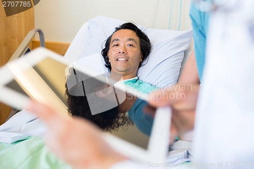 Image of Patient With Doctor Using Digital Tablet In Foreground