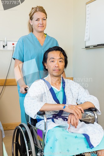 Image of Patient Sitting On Wheelchair While Nurse Assisting Him