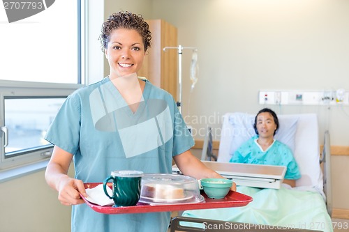 Image of Nurse Holding Breakfast Tray With Patient Lying On Hospital Bed