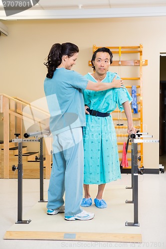 Image of Physical Therapist Assisting Male Patient In Walking