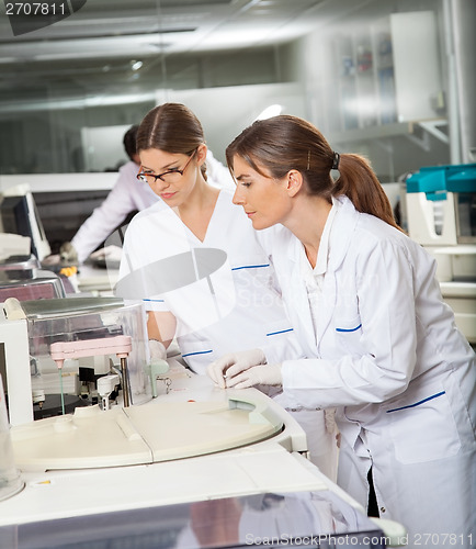 Image of Researchers Operating Machine In Lab