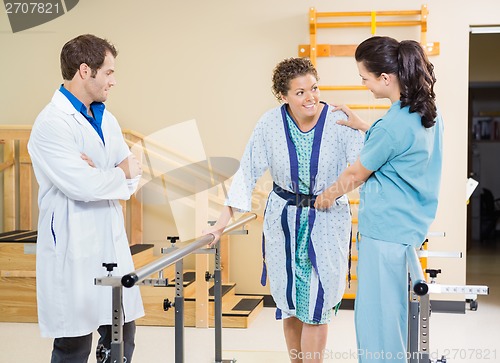 Image of Female Patient Being Assisted By Physical Therapists