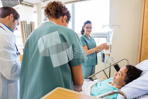 Image of Medical Team Examining Patient In Hospital