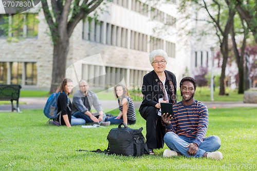 Image of Professor Helping Student on Digital Tablet