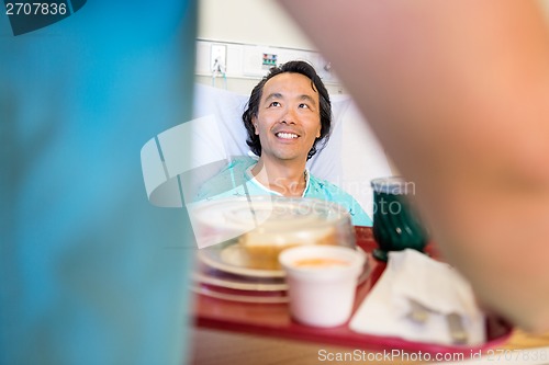 Image of Happy Patient Looking At Nurse Serving Breakfast