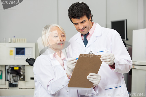 Image of Technicians Writing On Clipboard In Laboratory