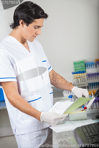 Image of Technician With Samples Analyzing Document