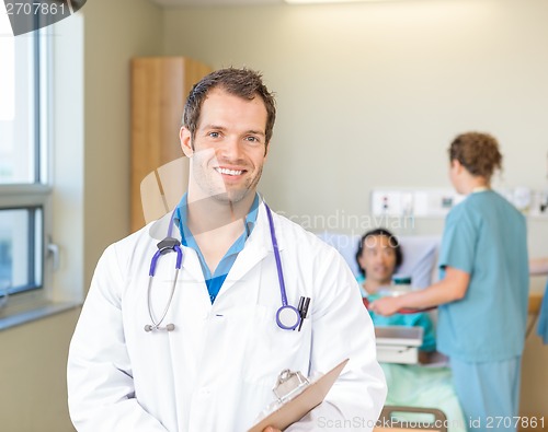 Image of Doctor Smiling While Nurses Examining Patient In Hospital