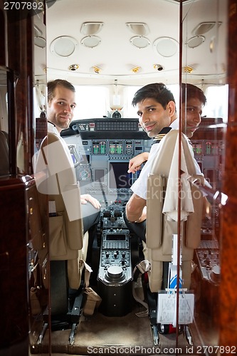 Image of Pilot And Copilot In Corporate Plane Cockpit