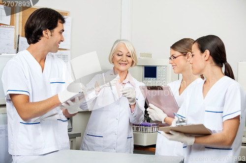 Image of Scientists Discussing Over Sample In Laboratory