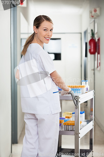 Image of Lab Technician Pushing Medical Cart In Corridor