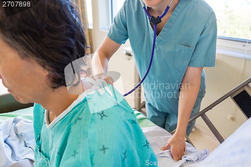 Image of Nurse Examining Patient's Back With Stethoscope