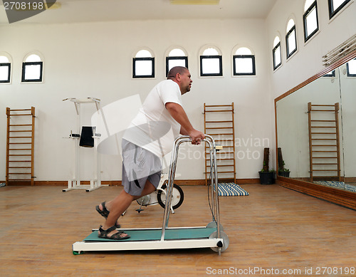 Image of overweight man running on trainer treadmill