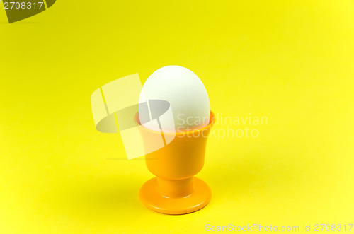 Image of Egg in cup at yellow background