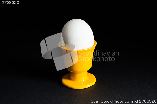 Image of Egg in cup at black background