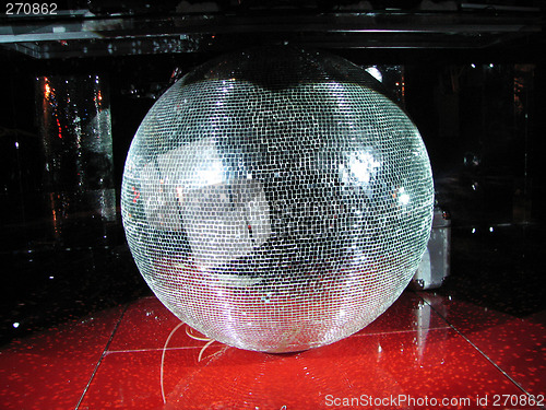 Image of Huge mirror sphere under the board of DJ in a night club