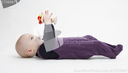 Image of baby lying on his back with toy
