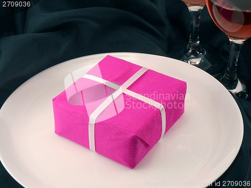 Image of Two champagne glasses and red gift box on white plate