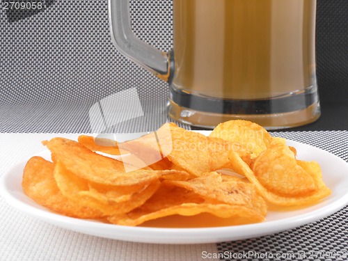 Image of Mug of Fresh Beer and plate with Pile potato chips