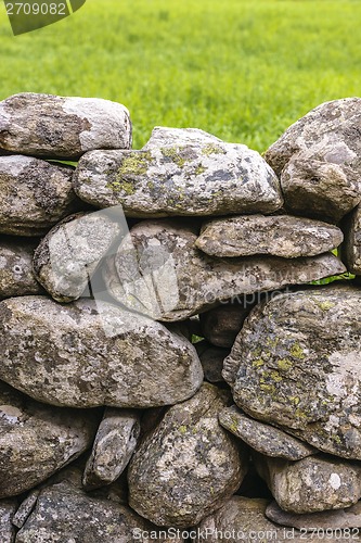 Image of Fence made of rough stones covered by moss