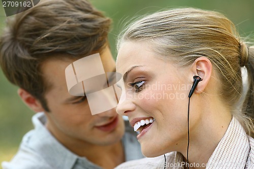 Image of beautiful couple listening player 