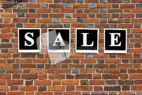 Image of inscription sale on the red brick wall