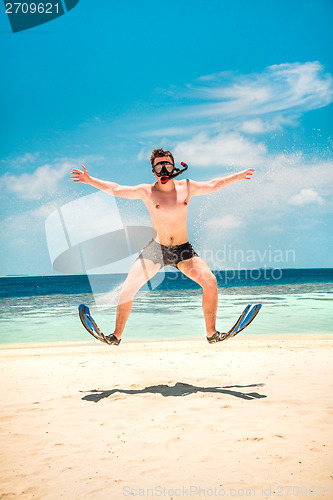 Image of Funny man jumping in flippers and mask.