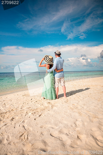 Image of Vacation Couple walking on tropical beach Maldives.