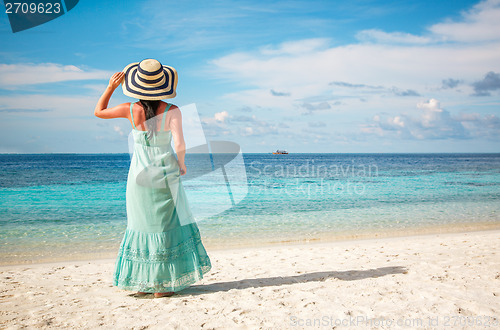 Image of Girl walking along a tropical beach in the Maldives.