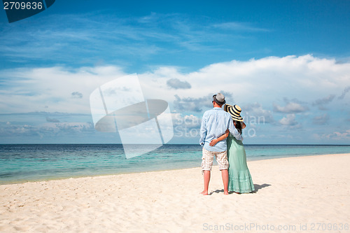 Image of Vacation Couple walking on tropical beach Maldives.