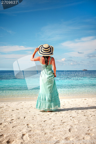 Image of Girl walking along a tropical beach in the Maldives.