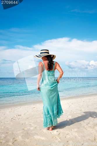 Image of Girl walking along a tropical beach in the Maldives.