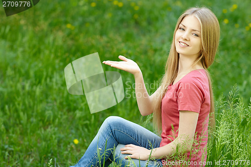 Image of Woman outdoors holding blank space on her palm