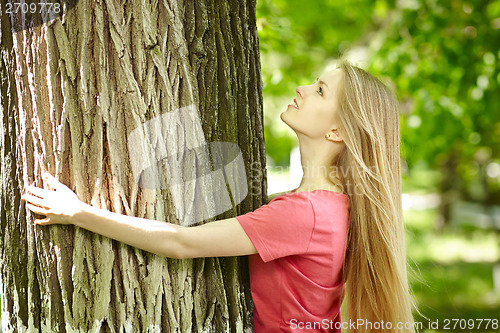 Image of Female hugging a tree, looking up