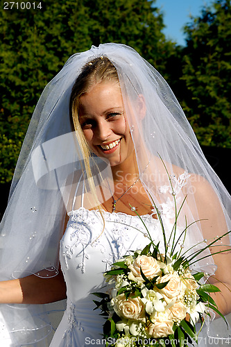 Image of Happy smiling wedding bride with bouquet.