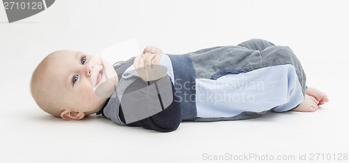 Image of smiling toddler laying on his back
