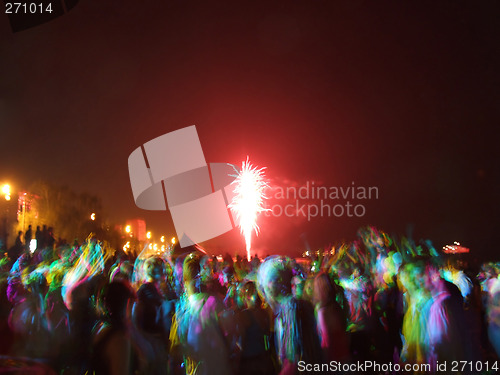 Image of Fireworks over the crowd of people dancing on the beach