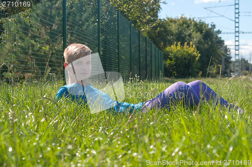 Image of Young man lying in a  green grass