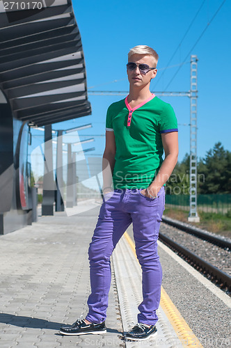 Image of Stylish man with sun glasses standing on platform