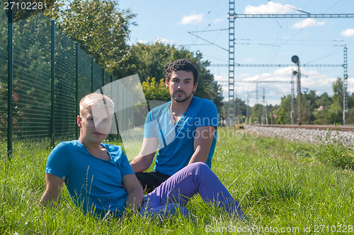 Image of Two guys sitting in a grass