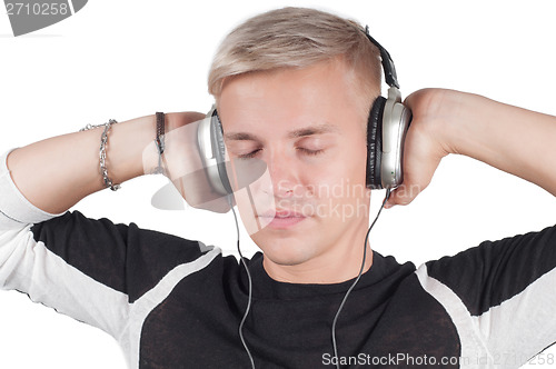 Image of Young blond man in headphones with closed eyes