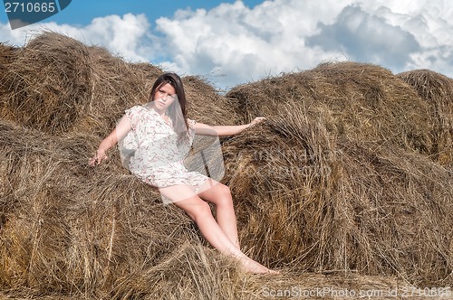 Image of Young beautiful woman on hay