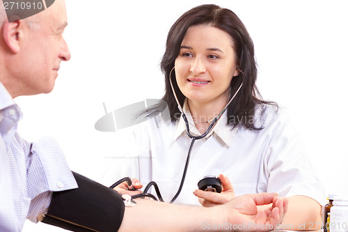 Image of doctor measuring  blood pressure  of senior man