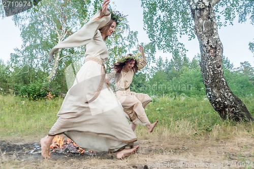 Image of Beautiful women jumping through fire