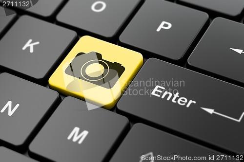 Image of Tourism concept: Photo Camera on computer keyboard background