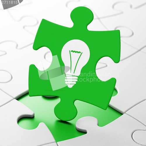 Image of Finance concept: Light Bulb on puzzle background