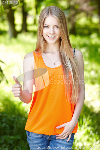 Image of Smiling female outdoors gesturing thumb up