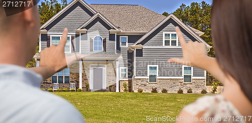 Image of House and Military Couple Framing Hands in Front