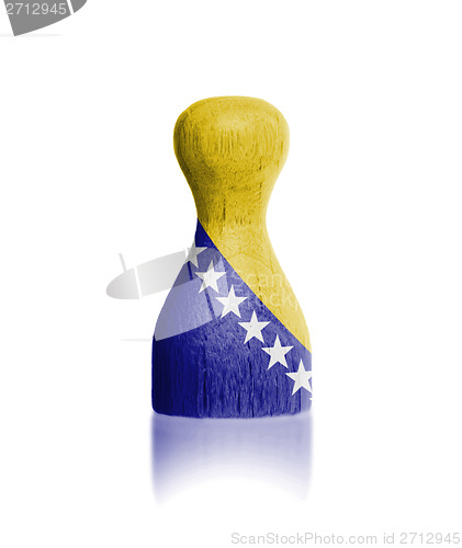 Image of Wooden pawn with a painting of a flag