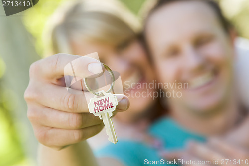 Image of Couple Holding House Key with New Home Text